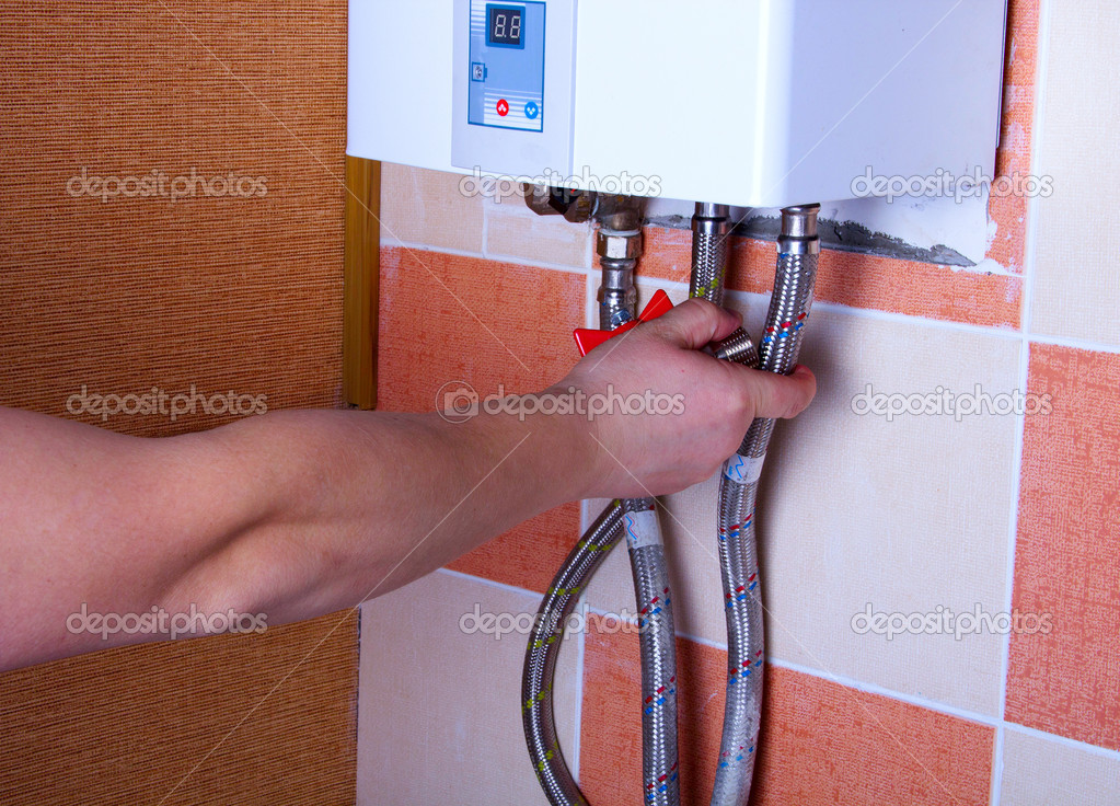 man tests the reliability of fastening of pipes in water heater